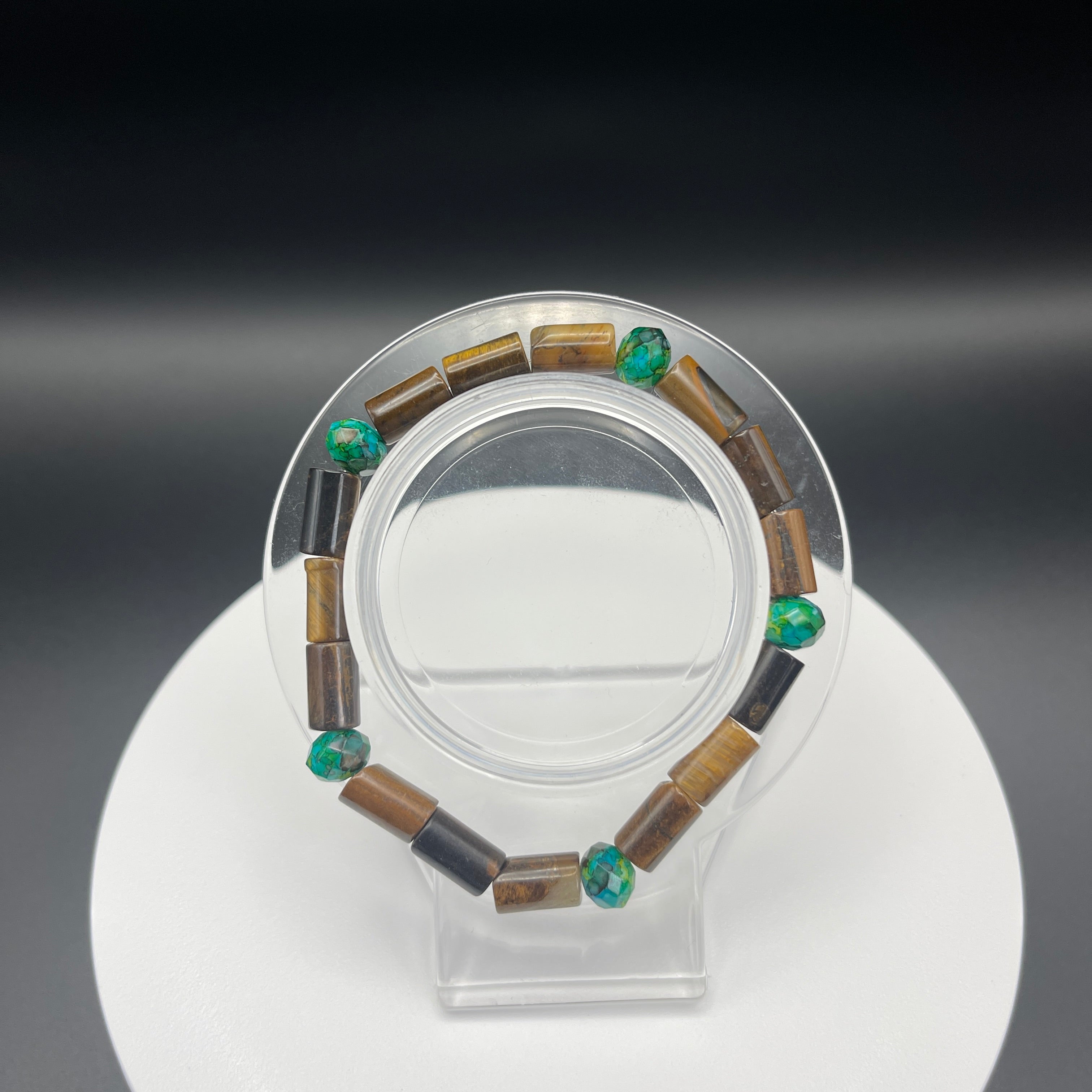 Beaded bracelet on a clear stand against a dark background